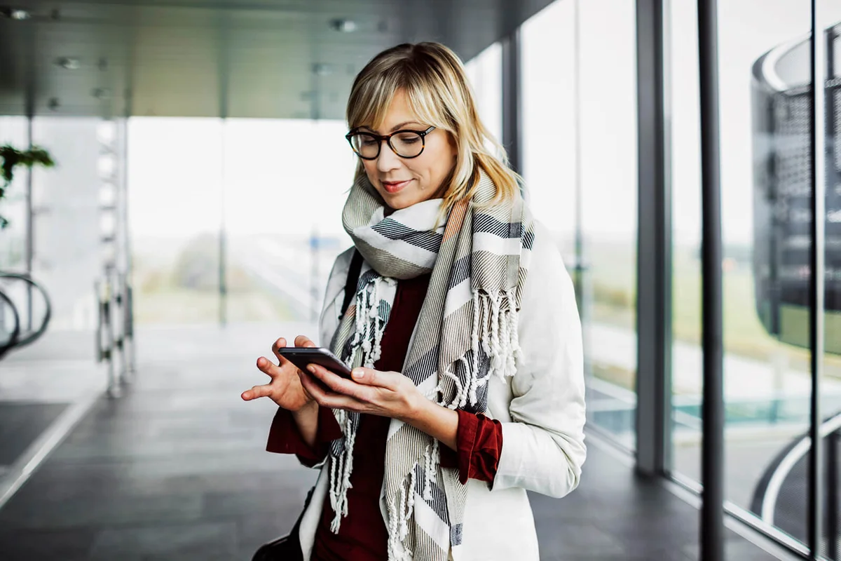 woman with smart phone standing at the airport
