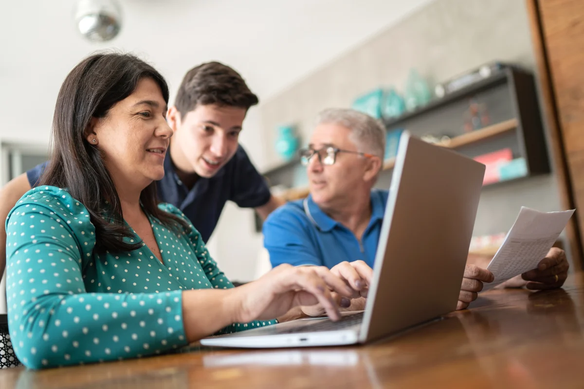 Parents doing home finances with their teenager son