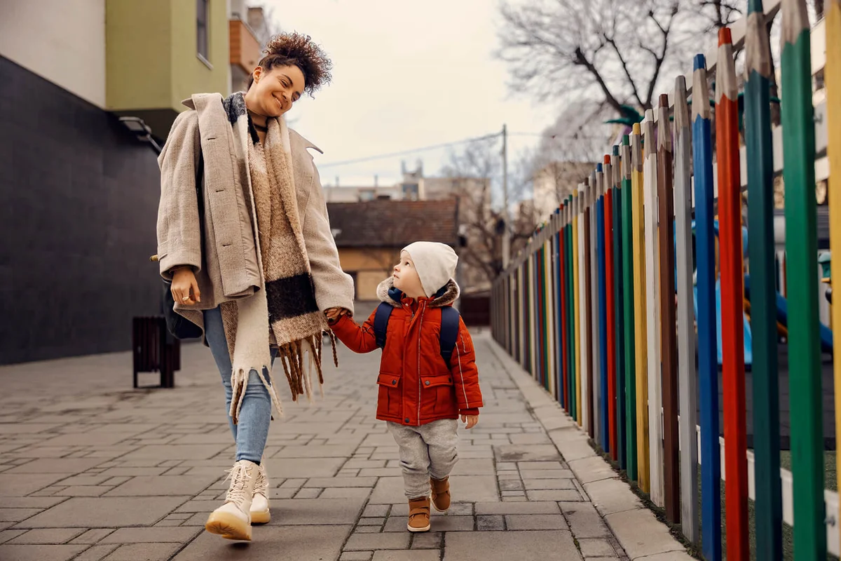 Babysitter taking kindergarten boy in kindergarten