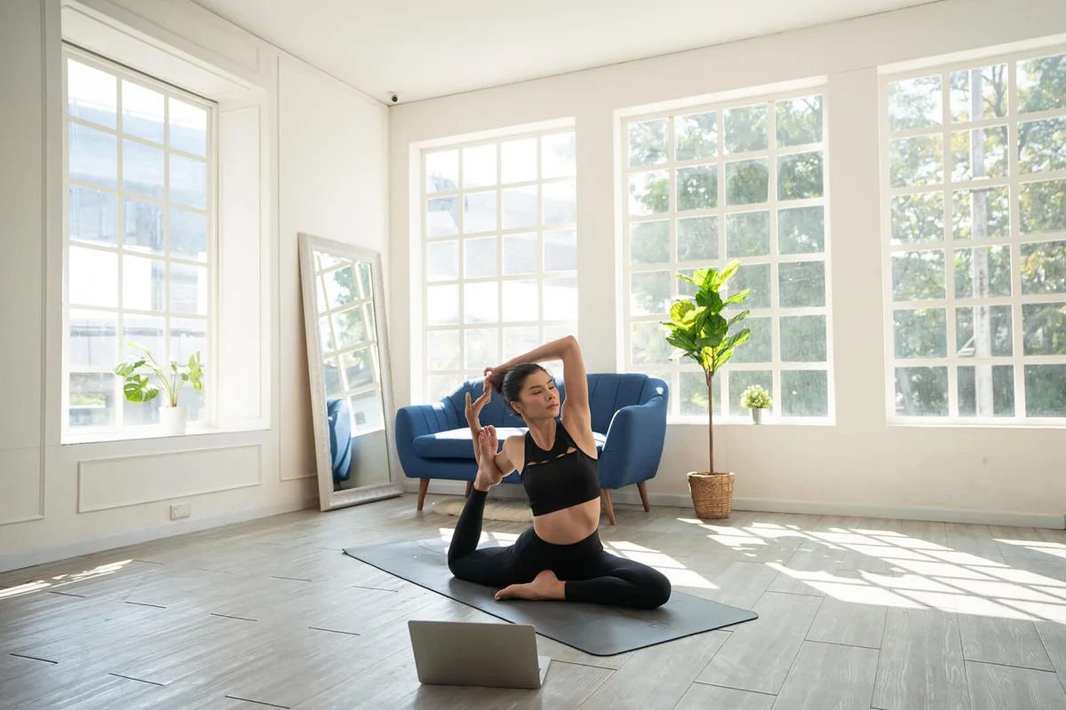 Young woman practicing iyengar yoga at home in her living room