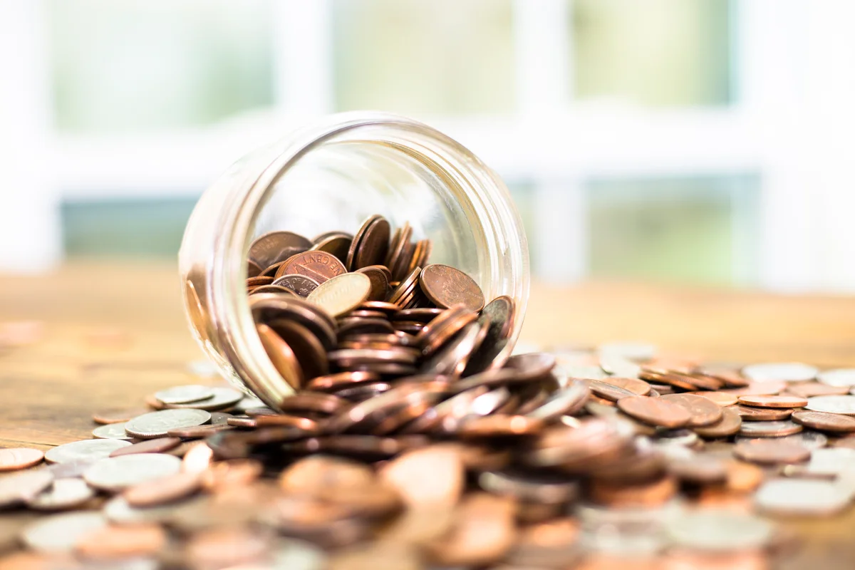 pennies flowing out of a glass jar