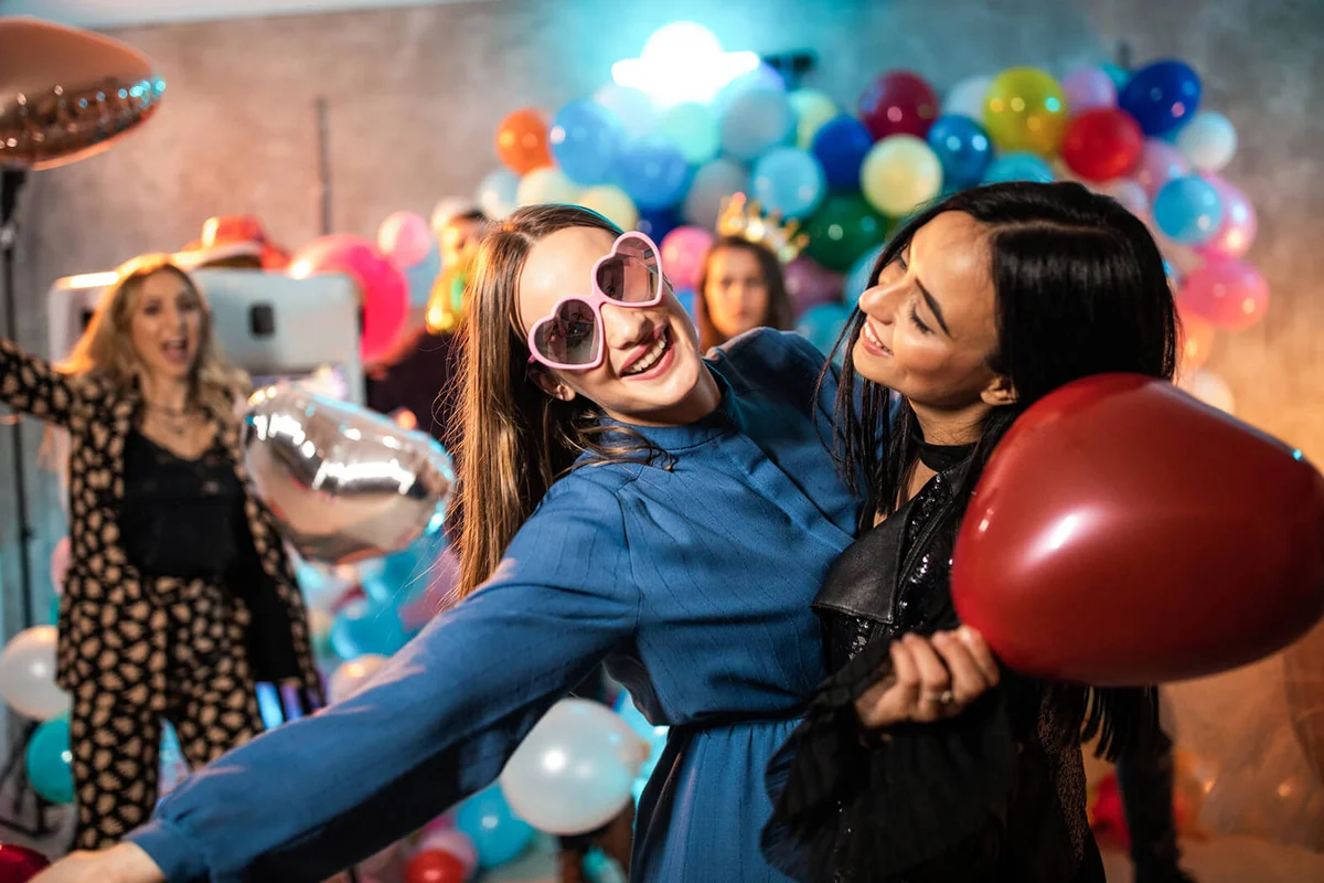 Two crazy female friends having fun at party