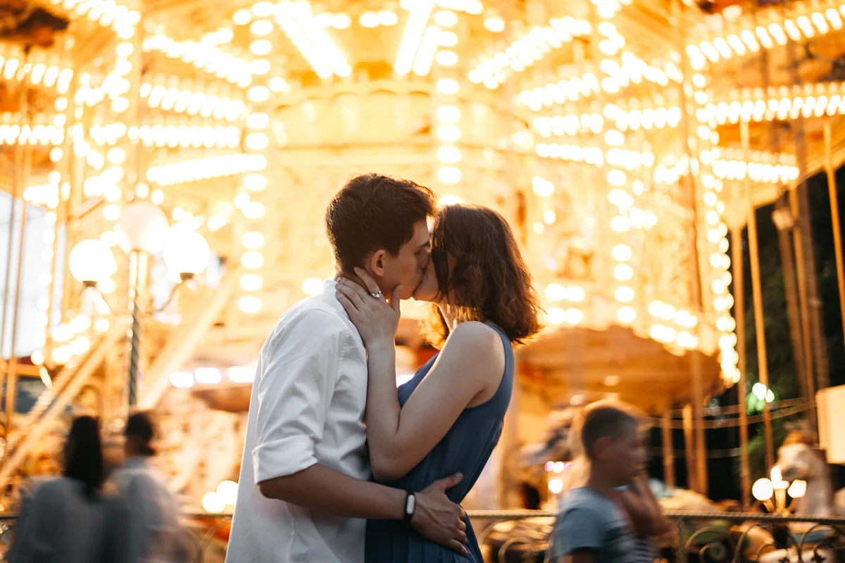 Couple kissing near the marry-go-round in the park