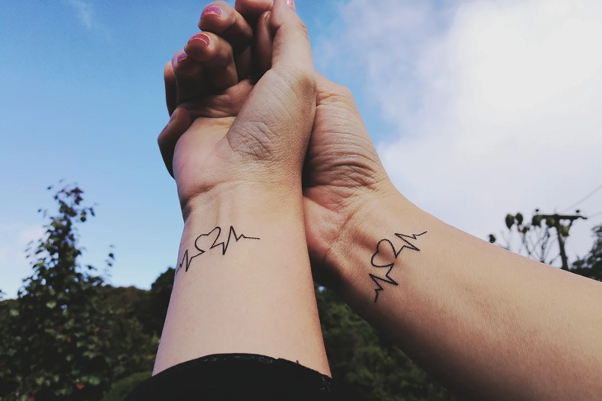Cropped Hand Of Couple With Tattoo