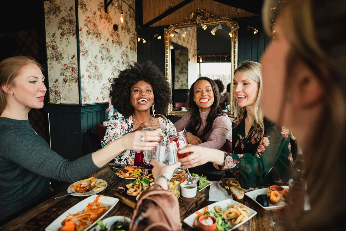 women enjoying a celebratory toast together in a bar.