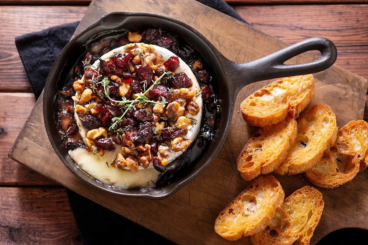 Baked Brie in a Cast Iron Skillet with Dried Cranberries, Chopped Walnuts, Maple Syrup and Thyme