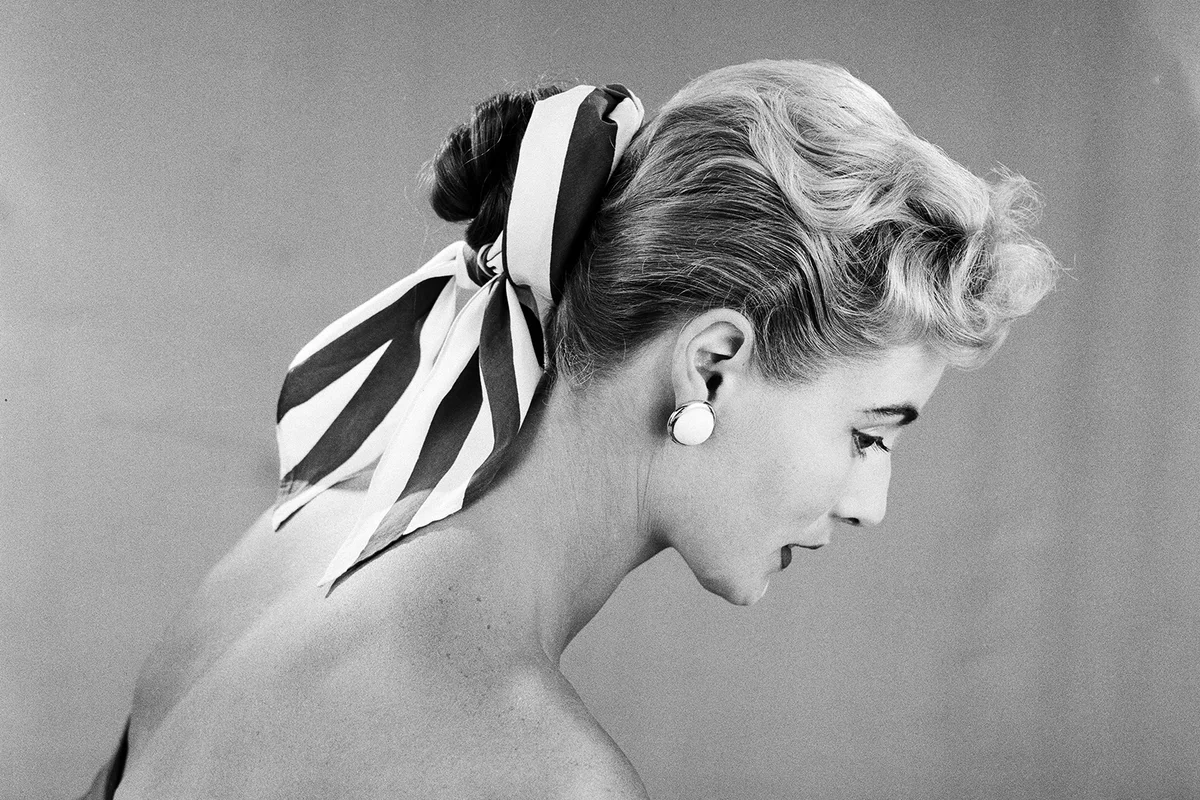 Cotton scarf and flower decorations for the hair, modelled by Pat O'Reilly. July 1955.