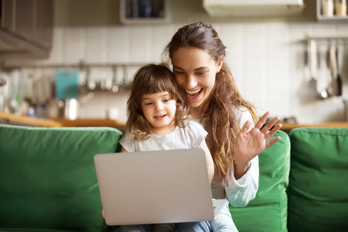 Happy mother and kid girl waving hands making video call
