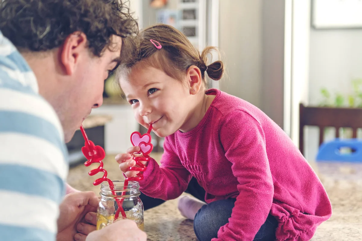 Father and daughter sharing a lemonade