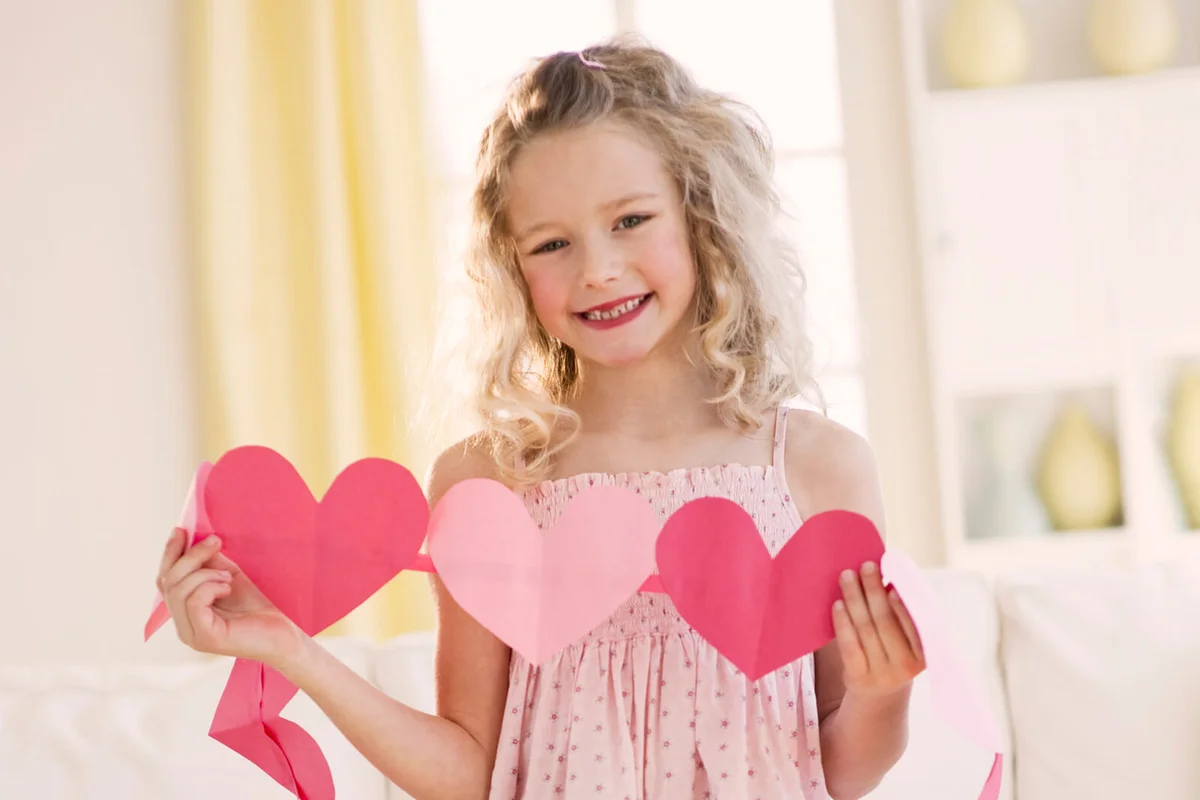 Young girl holding heart cut outs
