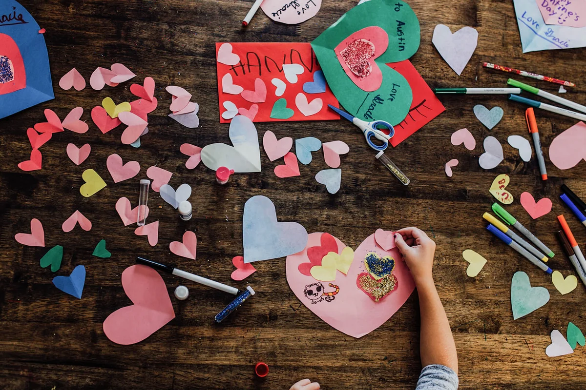 Overhead view of girl creating valentines crafts and cards