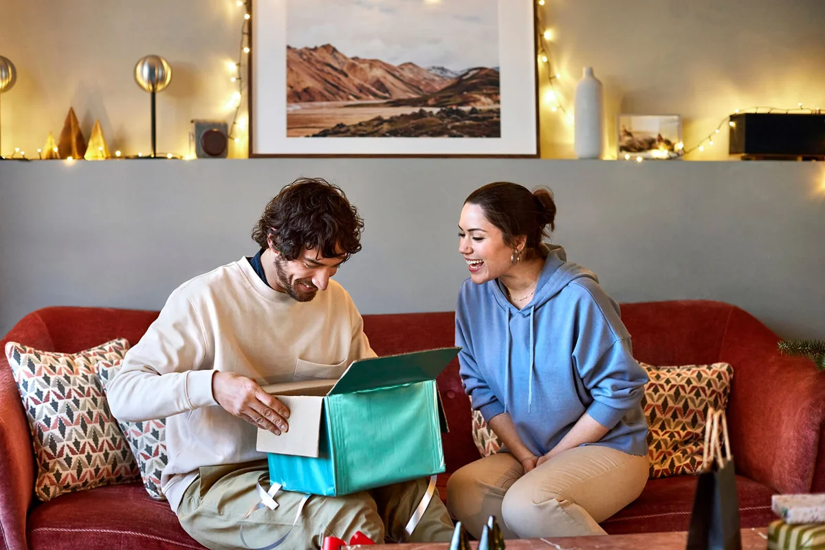 Happy couple with present at home