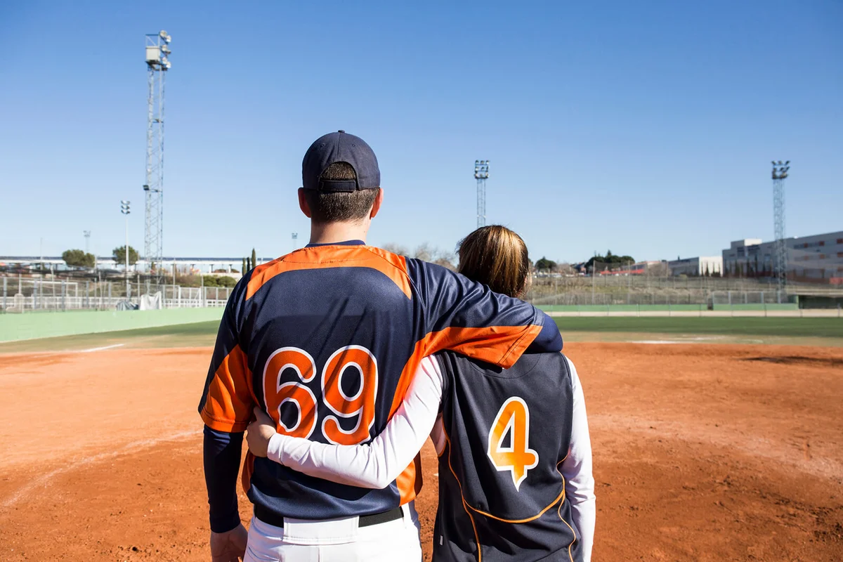 Couple baseball player embracing on a baseball field