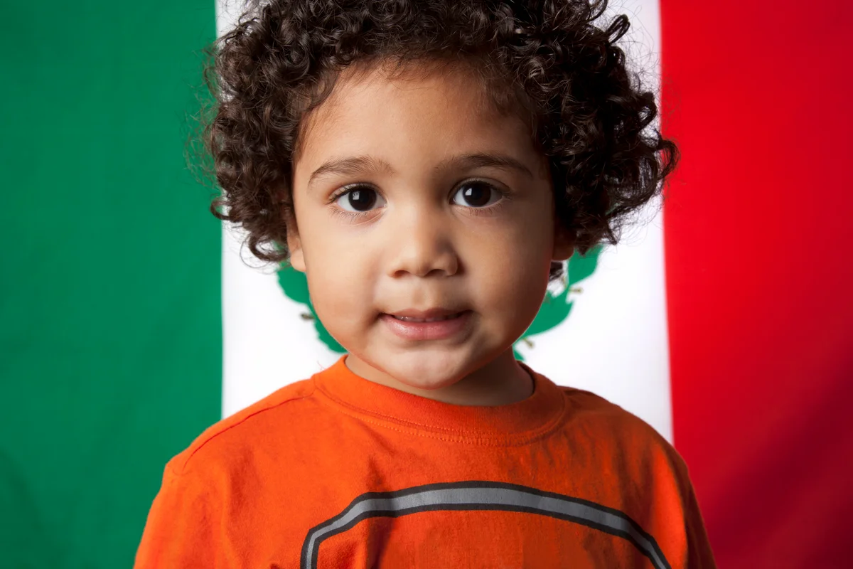 adorable young boy in front of a mexican flag