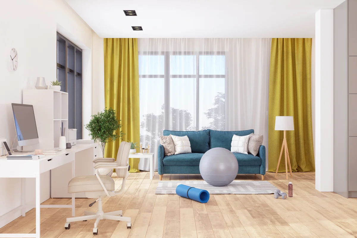 Living Room Interior With Sofa, Working Desk And Sports Equipment