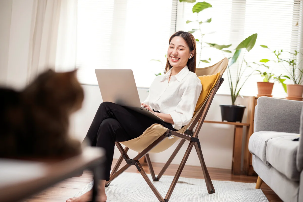 Cat looking at woman while she's working