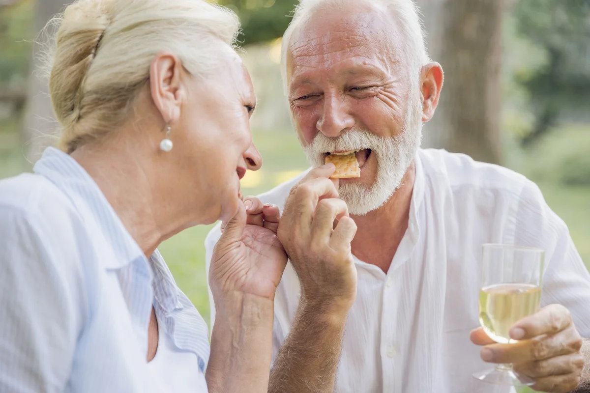 Couple snacking crackers and drinking white wine