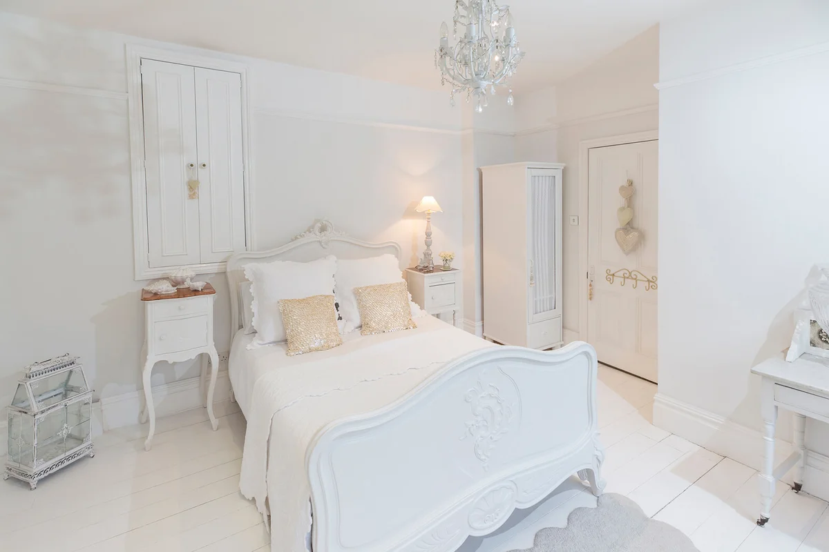 White, luxury home showcase bedroom with chandelier