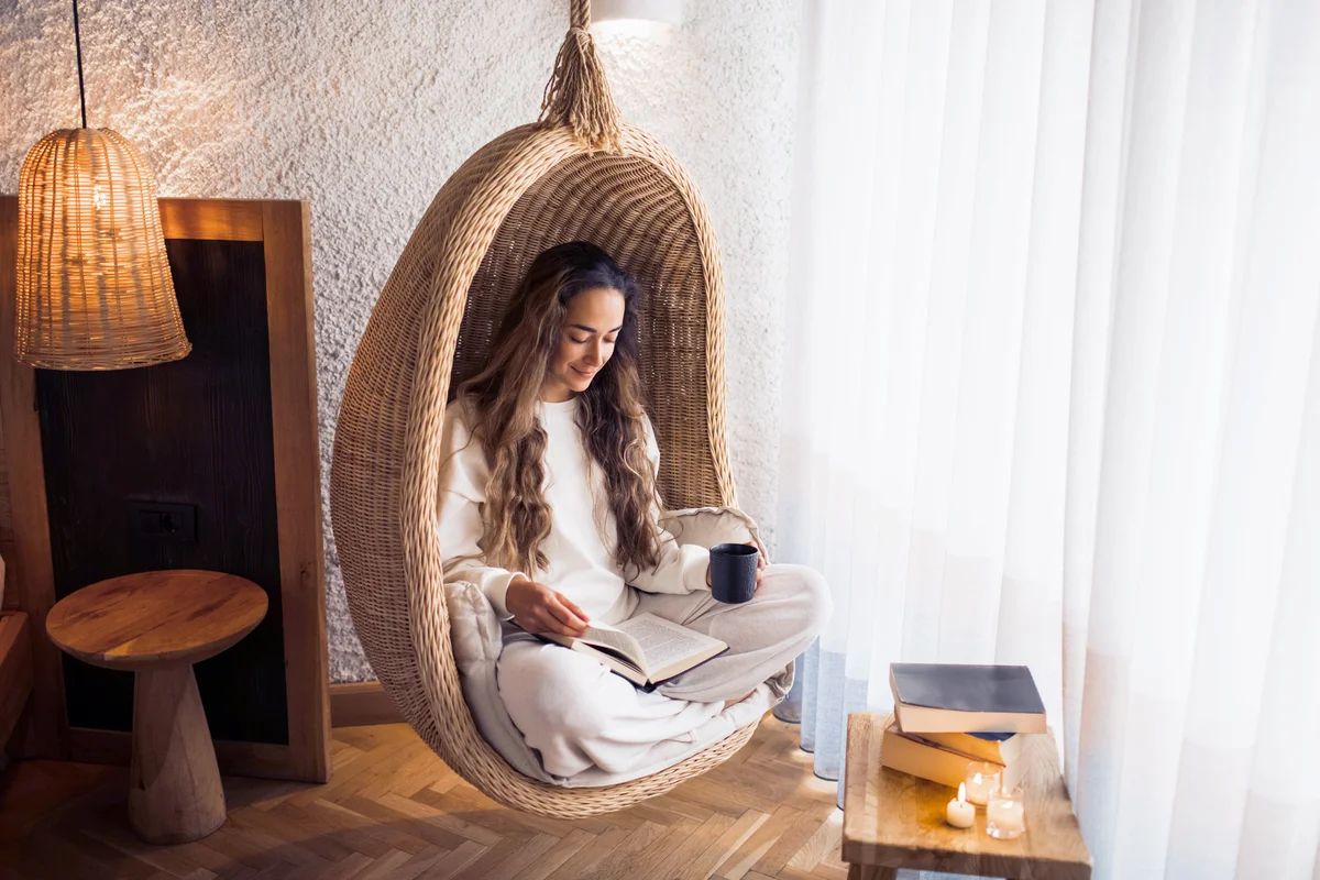 woman reading in a hanging ball chair