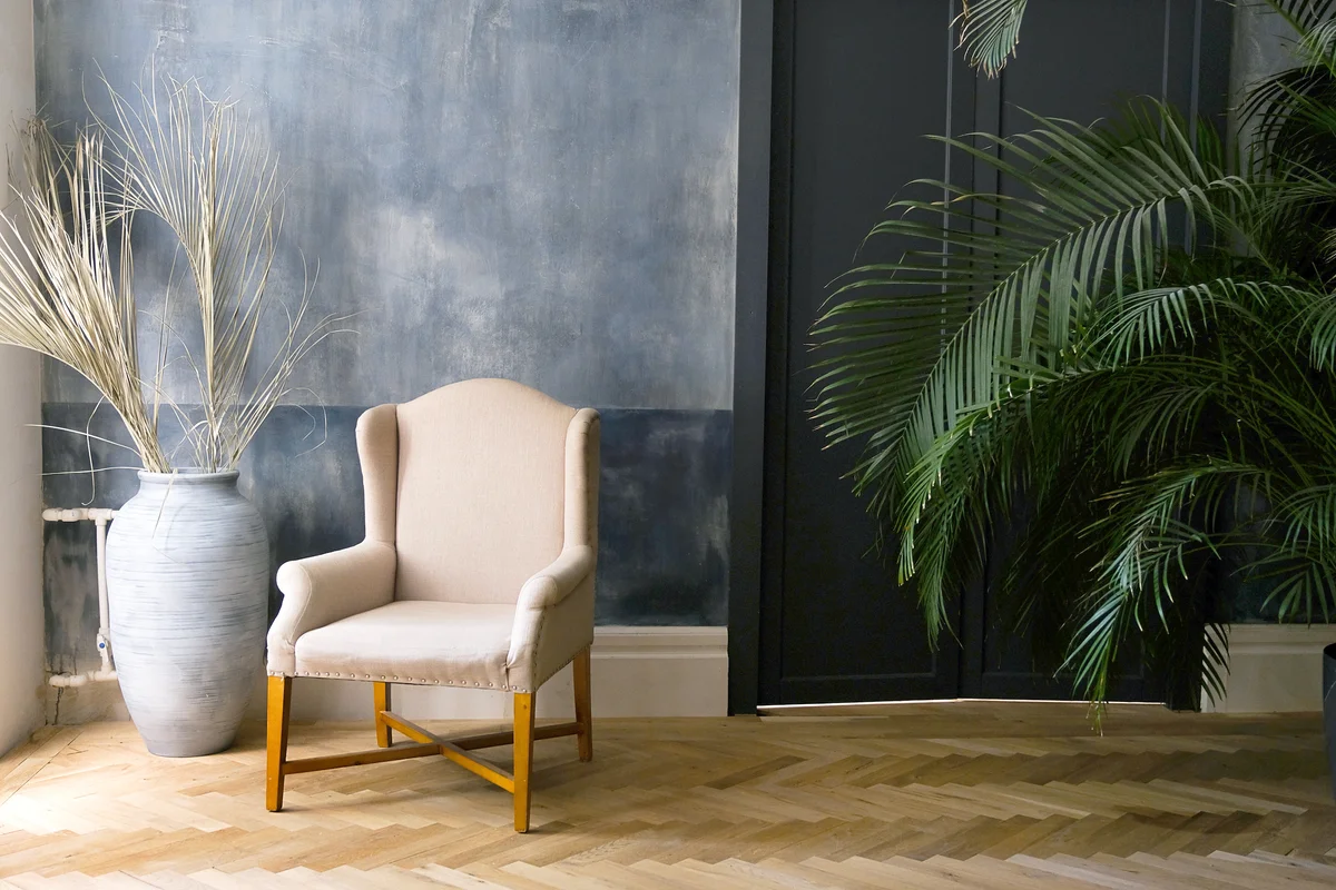 Beige chair and a large vase near the window