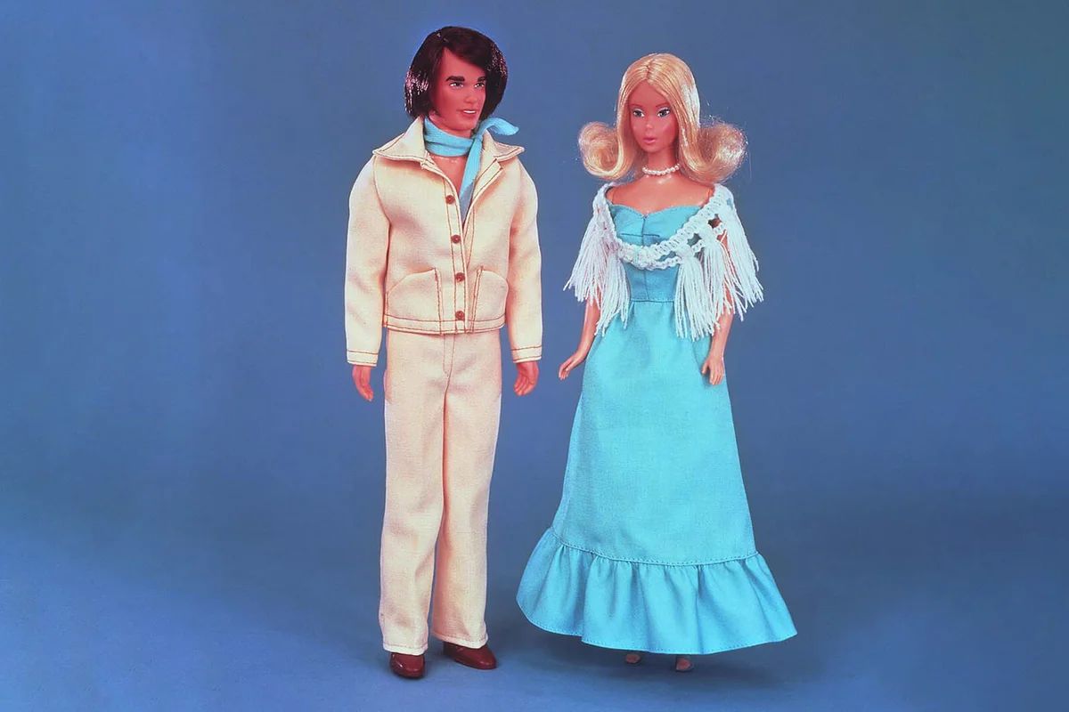 A 1977 Quick Curl Ken doll stands next to Barbie