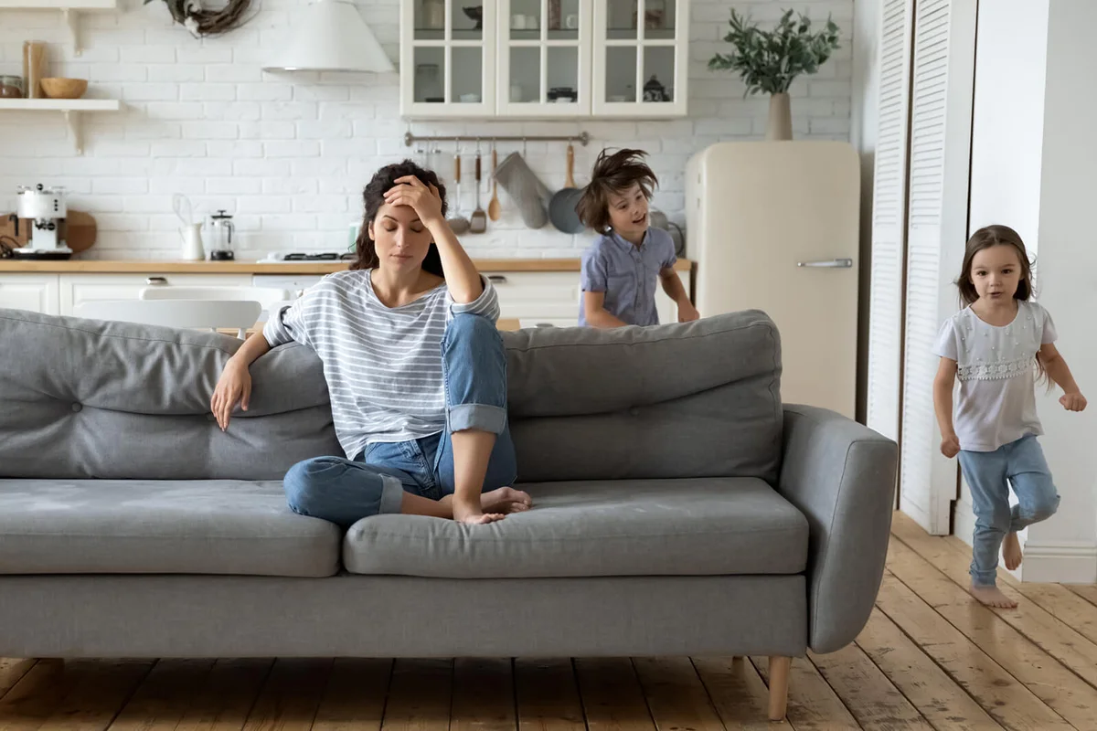 Exhausted young mother annoyed from loud children