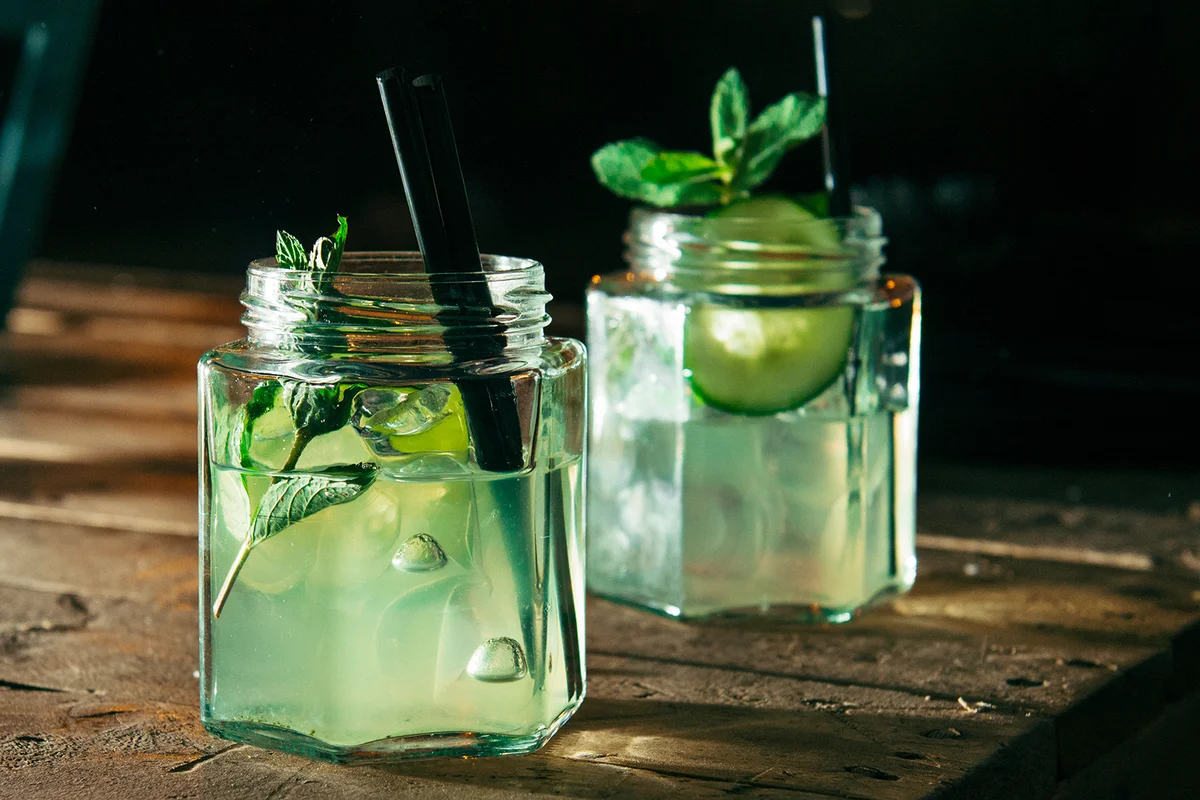 Close-Up Of Green Drinks In Jars On Table