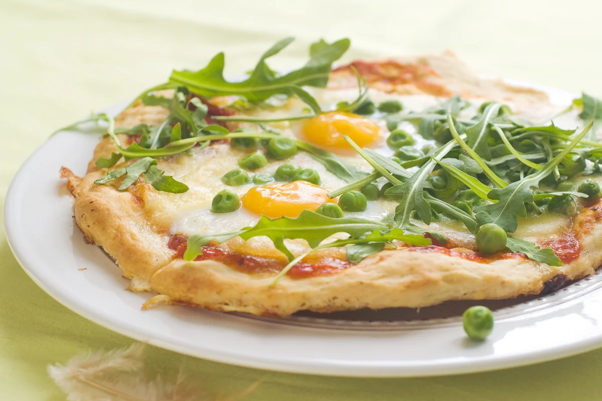 Pizza with eggs and green peas