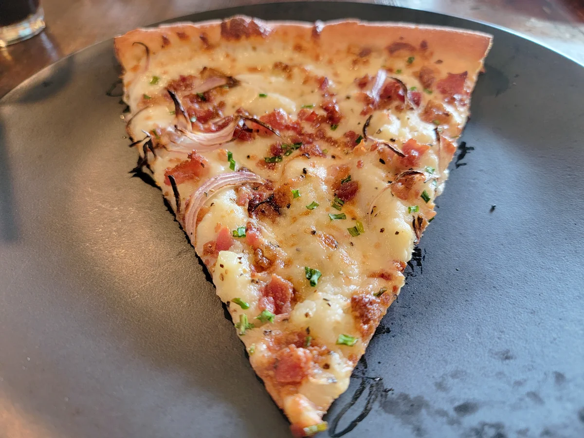 Slice of pizza with pepperoni onion and mashed potato