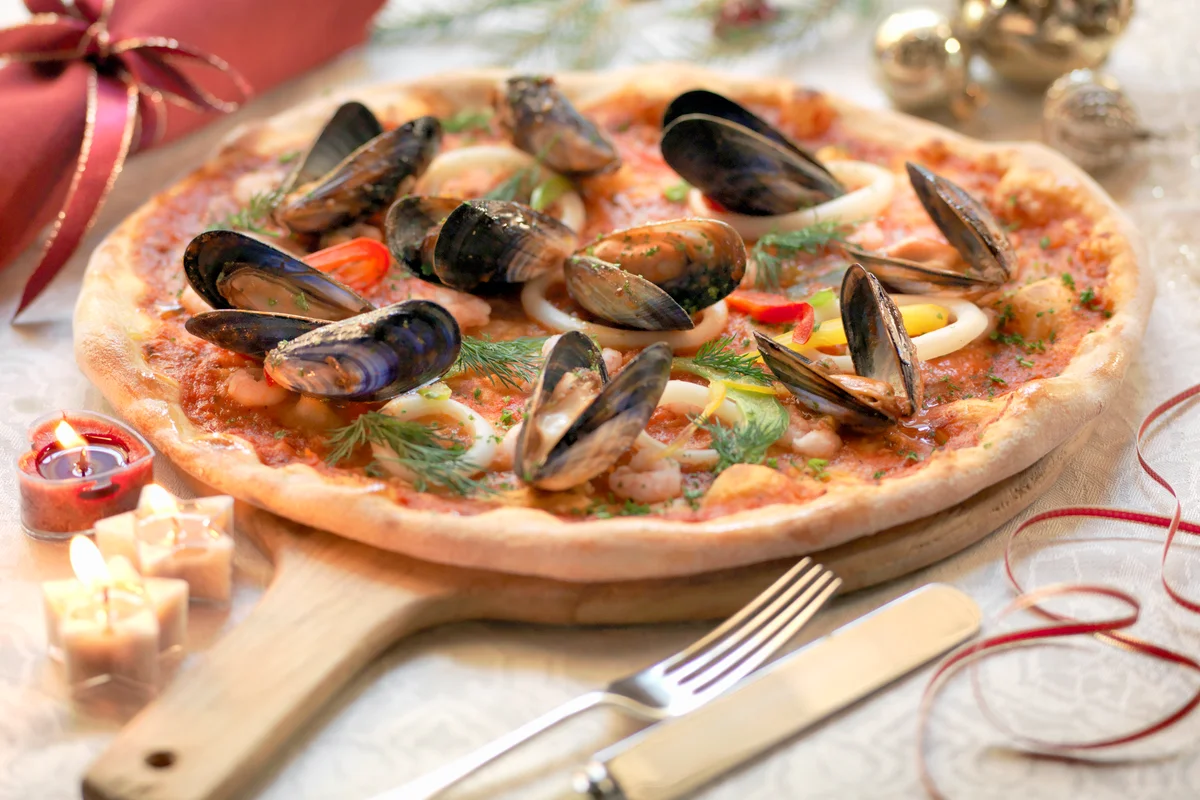 Homemade seafood pizza topped with calamari, prawns and mussels