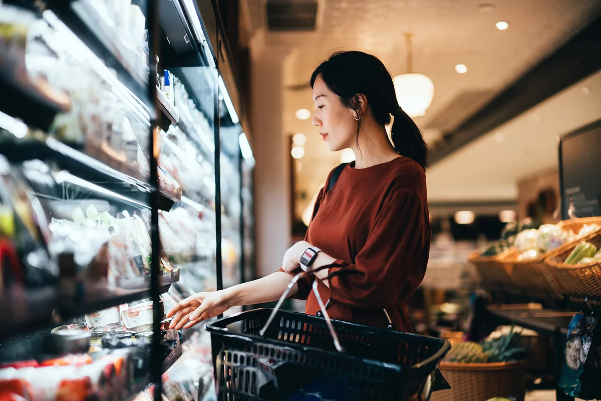 woman carrying a shopping basket, grocery shopping for daily necessities in supermarket