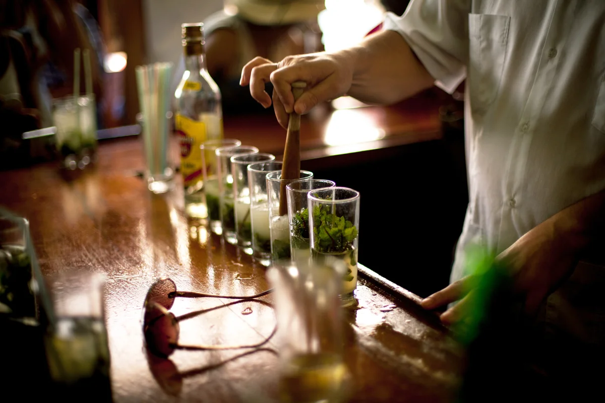 Bartender muddling mint for Mojitos