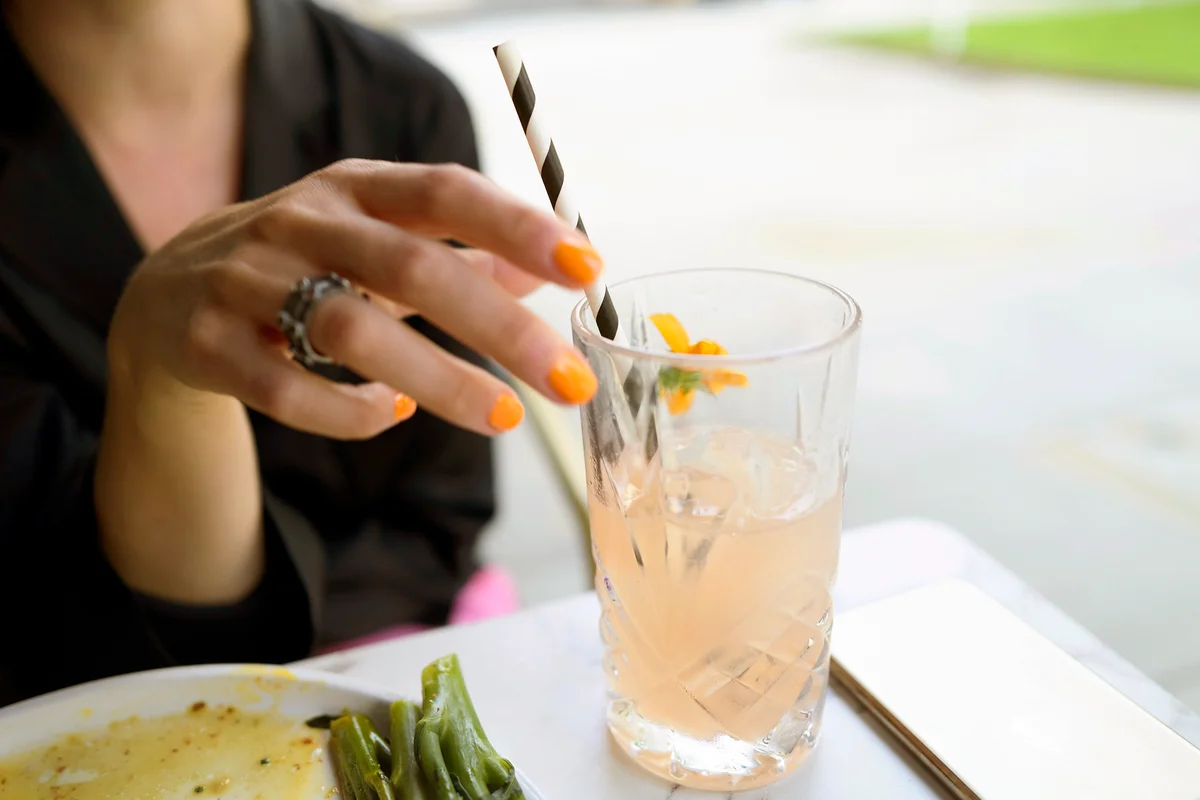 Woman holding a juice cocktail drink during brunch lunch