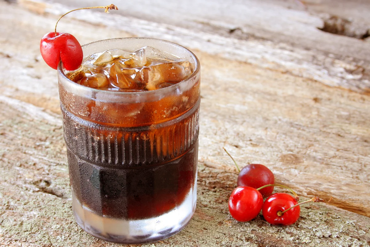 Glass of cherry soda with ice and rum
