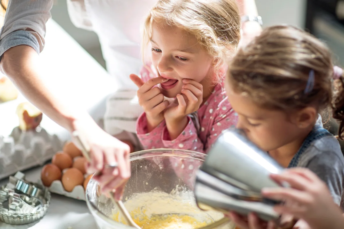 Mother and girls baking in kitchen