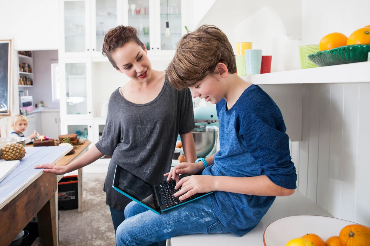 Young babysitter and boy in kitchen