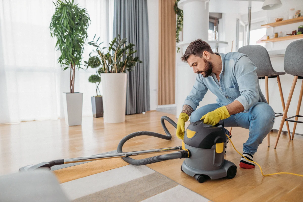 Man cleaning the vacuum cleaner