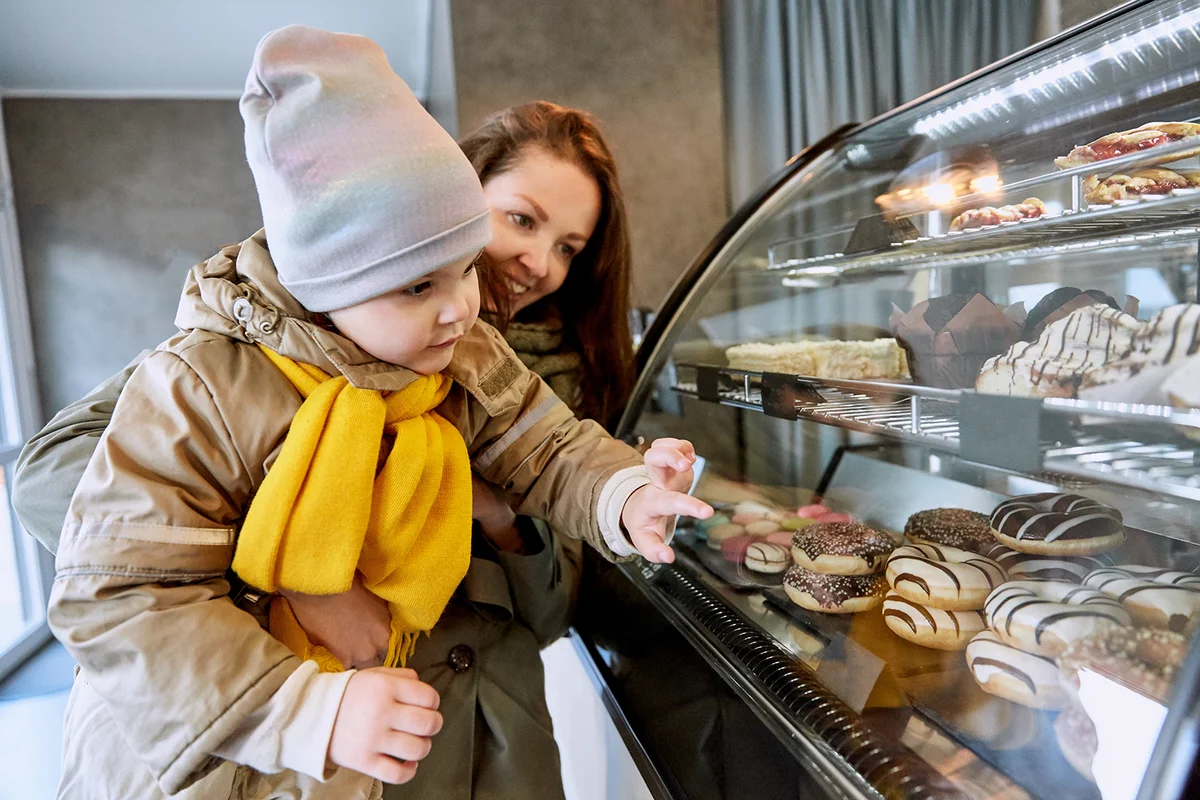 Mother and daughter choosing doughnut in a cafe