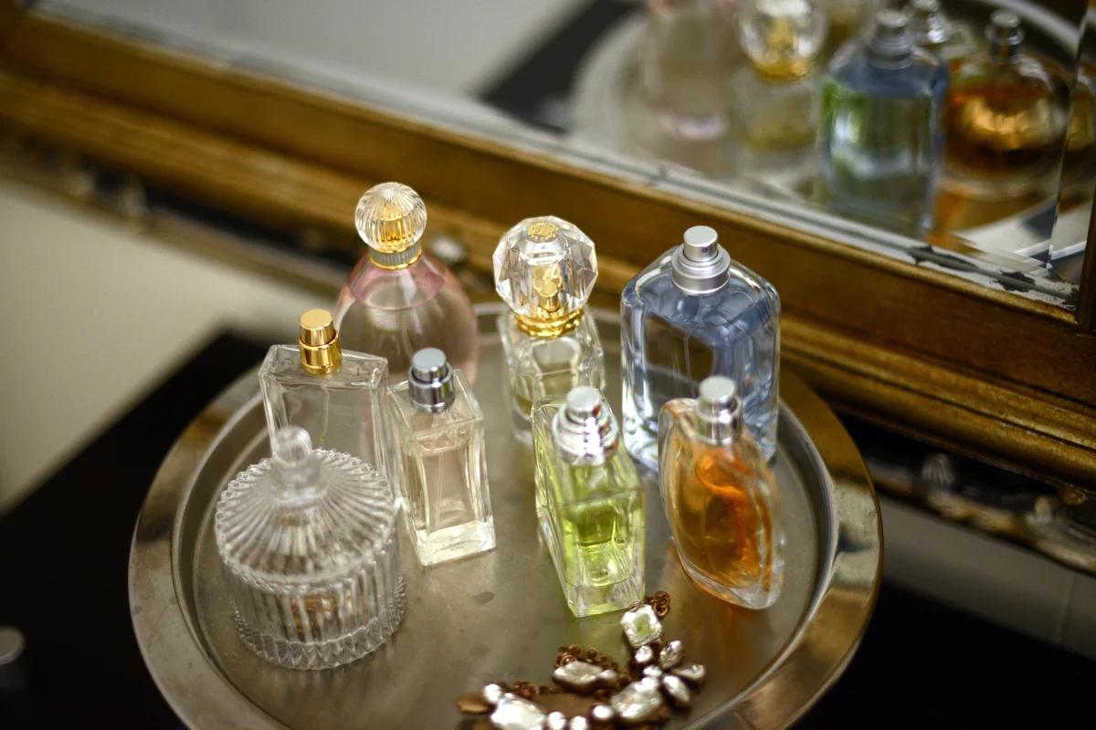 Perfume bottles on a tray by a mirror