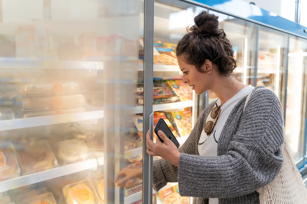 Young women customer searching in in frozen food case