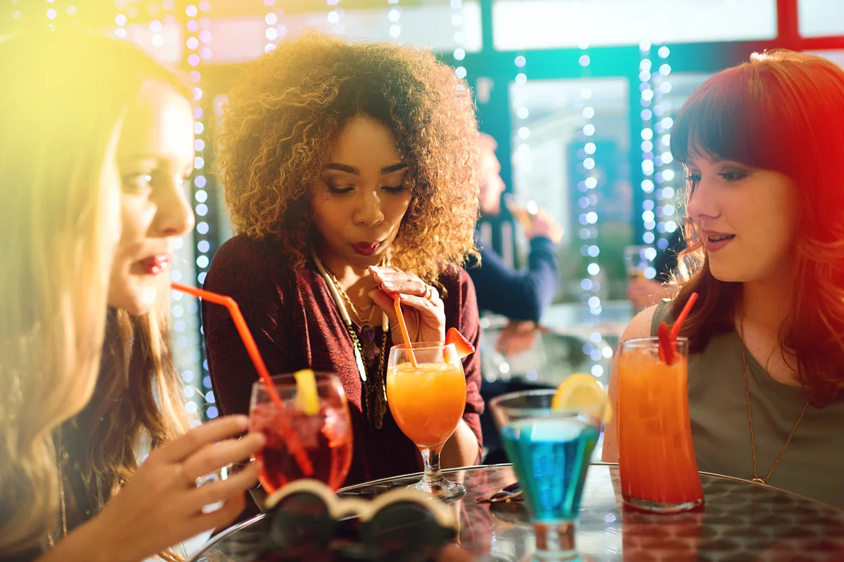 group of young friends having drinks together at a party