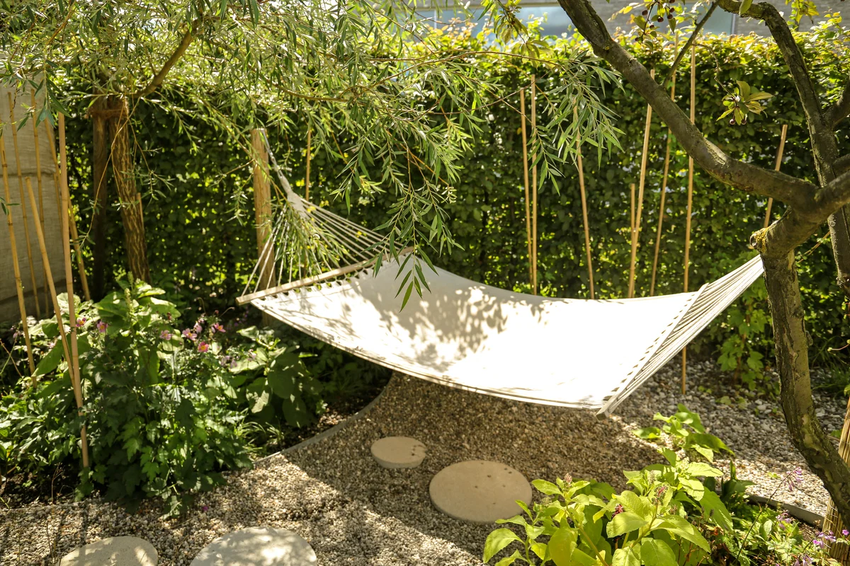 Summer garden with hanging hammock for relaxation