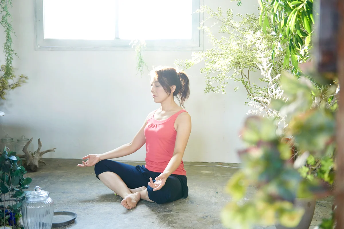 Woman doing yoga surrounded by plants
