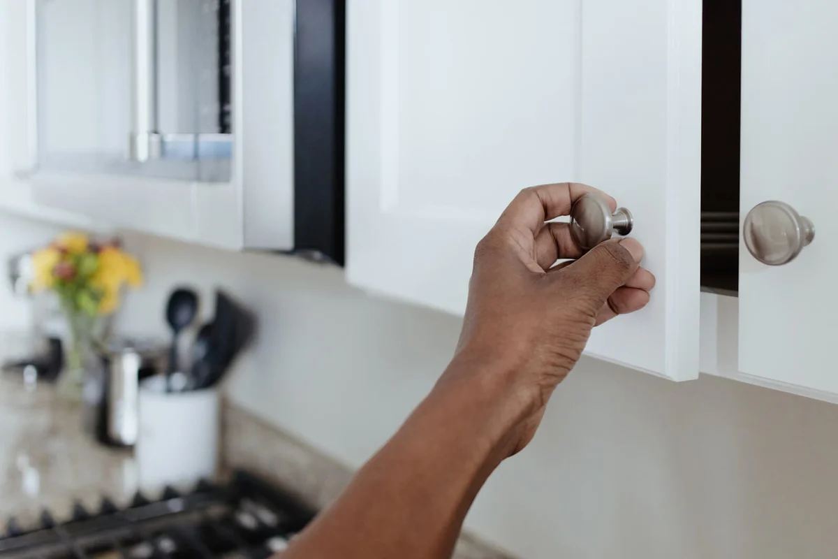 Woman Opens Kitchen Cupboard