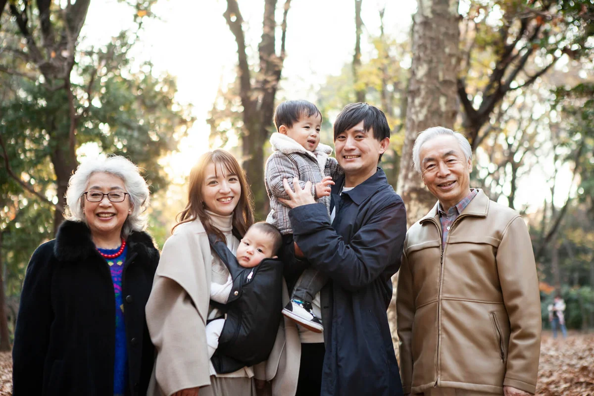 grandparents and parents on fallen leaves in the park