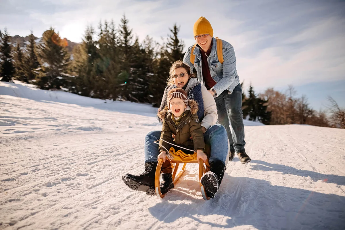 Family with one child enjoys a beautiful day in the snow