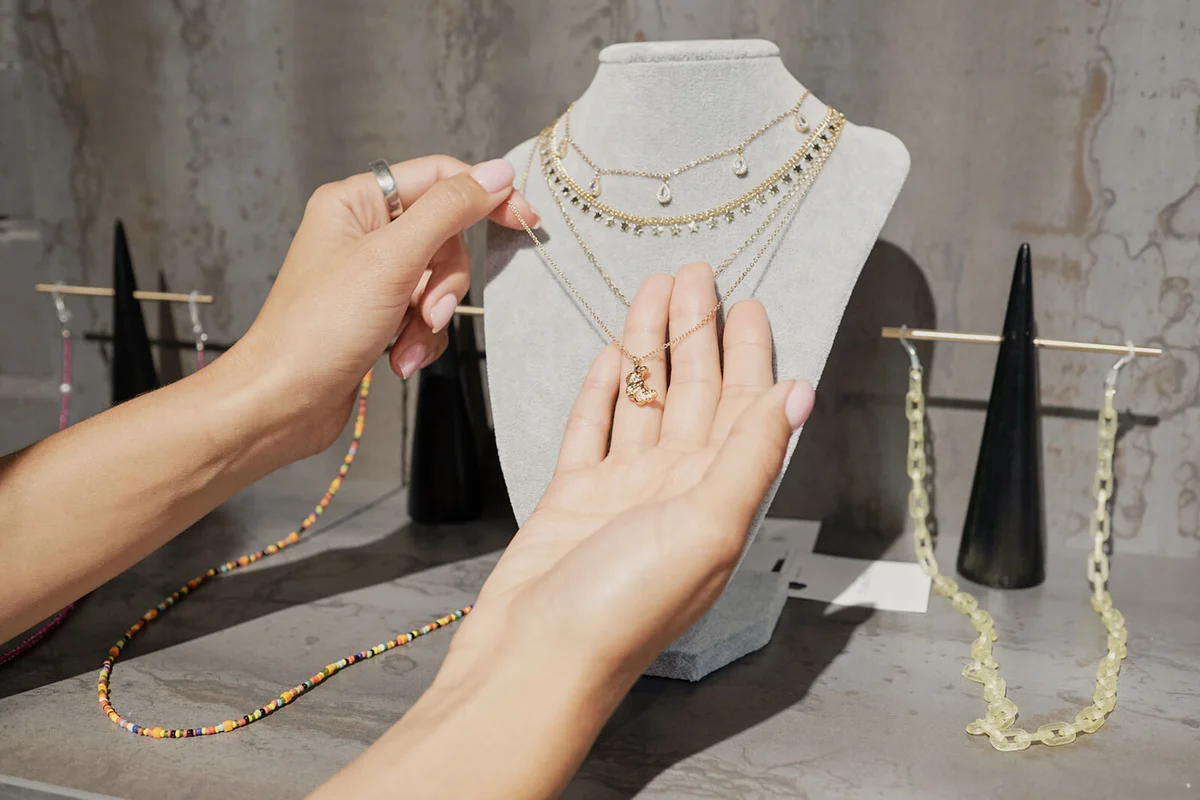 Hands of young woman holding golden chain with pendant