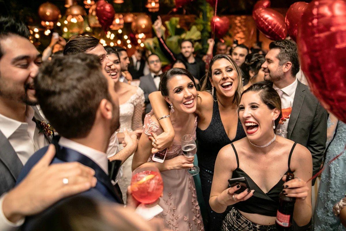 Groom and wedding guests laughing during party