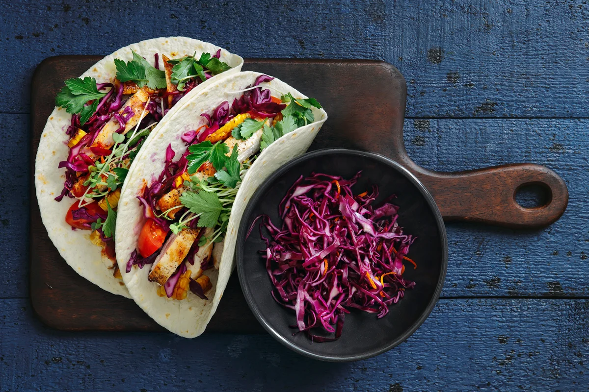 Grilled chicken tacos with coleslaw, vegetables and spicy sauce