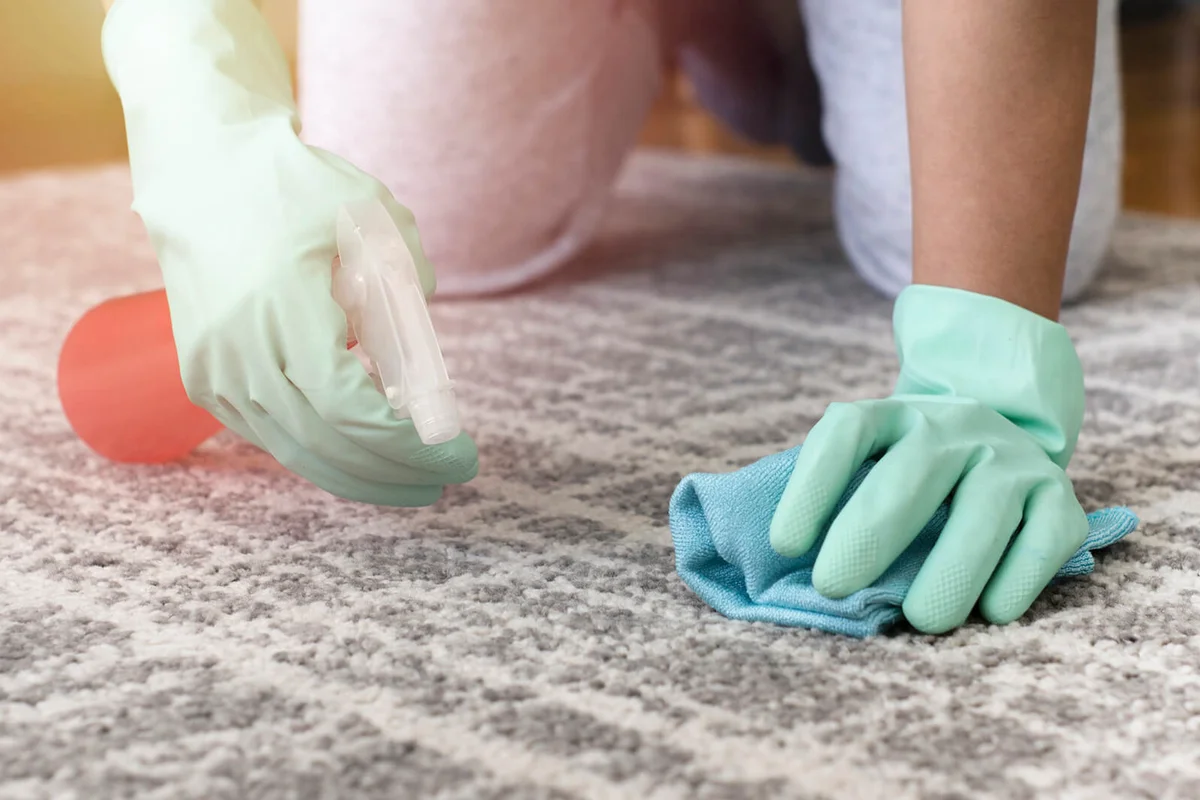 woman removing stain from the carpet